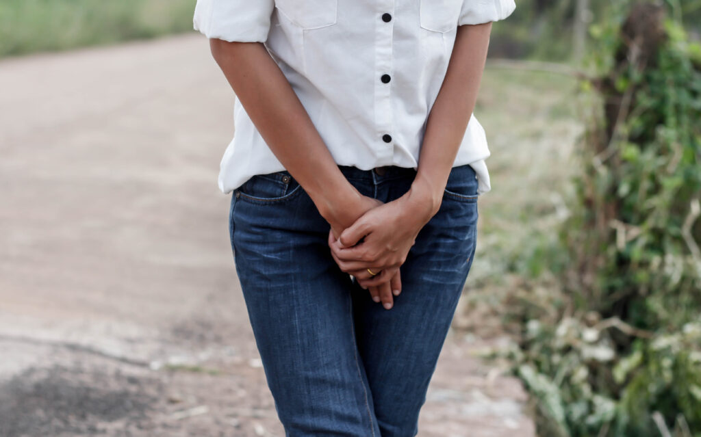 woman with hands holding her crotch